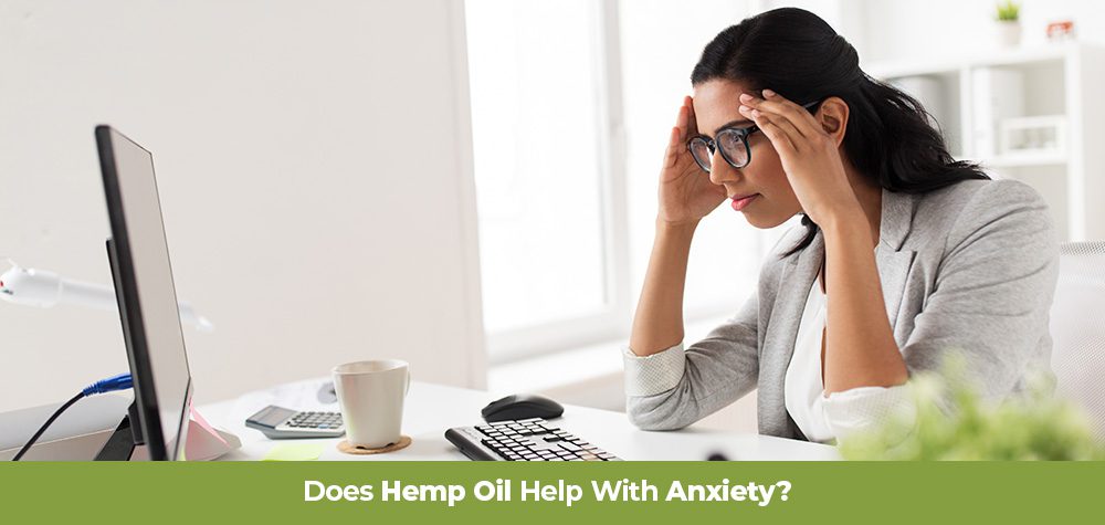 Anxious woman working at a computer holding her head. Does hemp oil help with anxiety? Buy all natural anxiety supplements online with hemp cbd.
